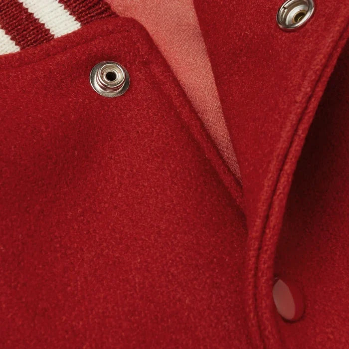 Close-up of a red fabric varsity jacket texture with metal buttons