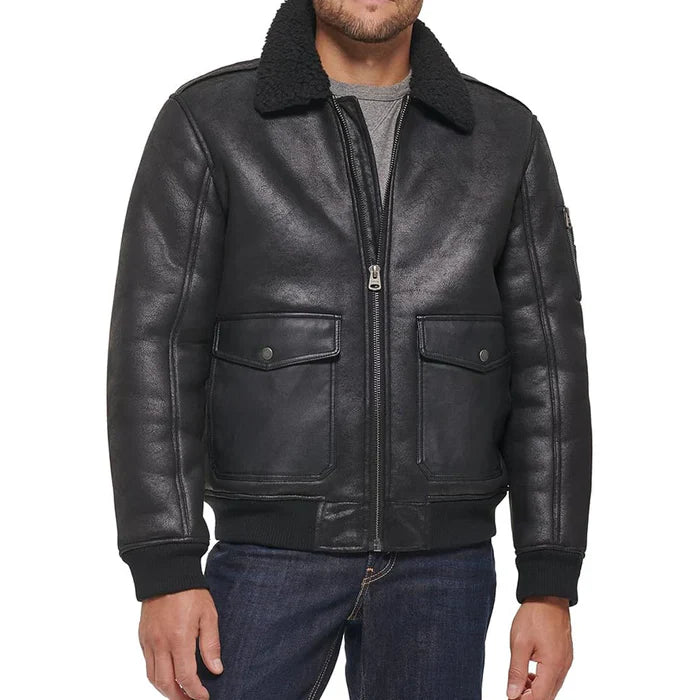 Front view of model wearing black aviator leather bomber jacket with a plush shearling-lined collar, silver-toned zippers, and black buttons.